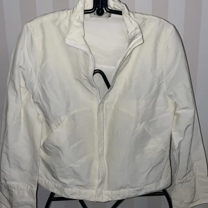 Vit jacka från Lipp st.134 - Säljer en stilren vit barnjacka från Lipp i storlek XSmotsvarar st.134. Jackan har en dragkedja framtill och långa ärmar. Perfekt för vår och sommar. Enkel och snygg design som passar till det mesta.