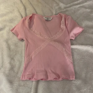 Rosa topp från Primark - Säljer en söt rosa topp från Primark med spetsdetaljer. Helt oanvänd. Storlek 2XS. Köpt i London.