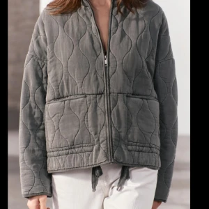 Grå quiltad jacka - Super fin jacka från Zara som är slutsåld, jätte fint skick!! Snygg grå quiltad jacka med dragkedja framtill. Jackan har en avslappnad passform och långa ärmar, perfekt för våren. 