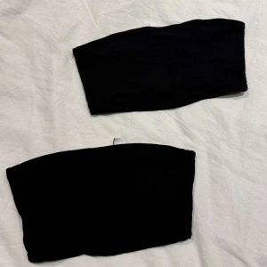 Svart tubtopp - Säljer två svarta tubtoppar. Perfekt för att matcha med olika outfits. Säljes endast tillsammans 