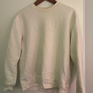 Vit sweatshirt - Säljer en stilren vit sweatshirt med rund hals och långa ärmar. Perfekt för en avslappnad look. Passar bra till jeans eller mjukisbyxor.