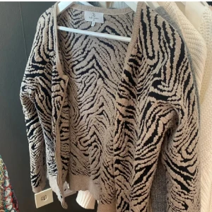 Zebramönstrad kofta - Snygg zebramönstrad kofta i beige och svart. Koftan har långa ärmar och en dragkedja framtill. Jag har sytt i högra ärmen då sömmen gick upp, men inget man tänker på (se bild 3) 