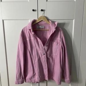 Rosa jacka från Zara - Säljer en snygg rosa jacka från Zara. Jackan har en avslappnad passform med knappar framtill och en klassisk krage. Perfekt för att ge en färgklick till din outfit. 🩷