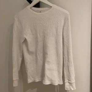 Vit långärmad tröja från H&M - Säljer en vit långärmad tröja från H&M i slim fit. Tröjan har en ribbad struktur och är perfekt för en stilren look. 