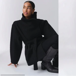 Svart kappa med bälte - Snygg svart kort kappa med bälte. Säljs pga den inte kommer till användning. Helt oanvänd och helt ny