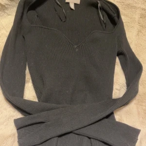 Svart ribbad tröja - Snygg svart ribbad tröja med långa ärmar och en v-ringad design. Perfekt för kyligare dagar och kan enkelt matchas med olika outfits. Tröjan har en stilren look och är både bekväm och trendig.❤️