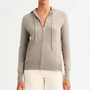 Beige kofta med dragkedja - Säljer en stilren beige kofta med dragkedja och huva. Tröjan har långa ärmar och är tillverkad i ett mjukt material som ger en bekväm passform. Perfekt för kyligare dagar.