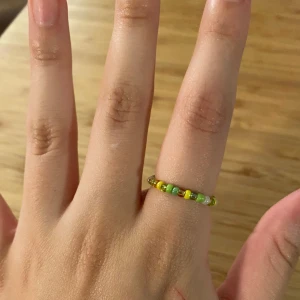 Grön & gul ring, pärlor - Egentillverkad ring av pärlor och ståltråd💚💛ca 8cm omkrets och ca 18mm diameter. Går att beställa i valfri färg/färger💅🏼