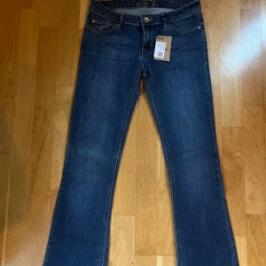 Blå jeans från Zara - Snygga blå jeans från äldre kollektion av Zara med en klassisk femficksdesign och knappgylf. De har en bootcut-stil som ger en trendig look. Storleken är 38 men skulle kanske mer säga att det är en storlek 36! Inga slitningar 