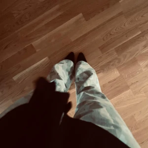 Cargobyxor med blått kamouflagemönster - Snygga cargobyxor med ett coolt blått kamouflagemönster. Byxorna har en loose passform och är perfekta för en avslappnad stil. De är tillverkade i ett bekvämt material som passar bra för vardagsbruk.