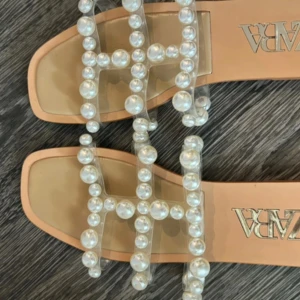 Beige sandaler med pärlor från Zara - Stilrena beige sandaler från Zara med dekorativa pärlor på remmarna. Perfekta för sommarens alla tillfällen. Sandalerna har en fyrkantig tå och ger en elegant touch till din outfit.