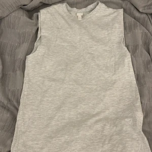 Grå ärmlös klänning - Säljer en grå ”mjukis” klänning. Perfekt för en avslappnad look. Klänningen har en rak passform och är gjord i ett mjukt material.