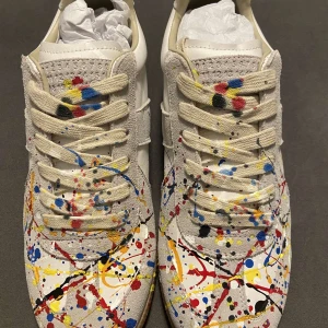 Maison Margiela sneakers - Unika sneakers från Maison Margiela med ett kreativt färgstänksmönster i flera färger. Skorna har snörning och en beige bas med färgstänk i rött, blått, gult och svart. Sulan är i gummi med ett distinkt mönster för bra grepp. För flera frågor skriv DM‼️‼️