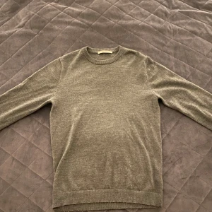 Grön-grå tröja från A day’s march - Grön-grå tröja från A day’s march i merinoull. Tröjan är i storlek Medium men är rätt liten i passformen. Därför rekommenderar jag tröjan till den som i vanliga fall har storlek Small.