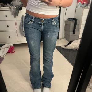 Blå bootcut jeans - Snygga blå bootcut jeans med låg midja och klassisk femficksdesign. Perfekta för en avslappnad stil. 