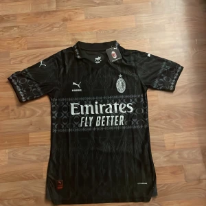 Svart AC Milan fotbollströja från Puma - Snygg svart AC Milan fotbollströja från Puma, helt ny