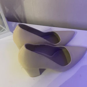 Beige pumps med klack - Snygga beige pumps med spetsig tå och stabil klack. Perfekta för en elegant look. Tillverkade i syntetmaterial. Dessa är ifrån nelly och ja har använt de endast 3 gng