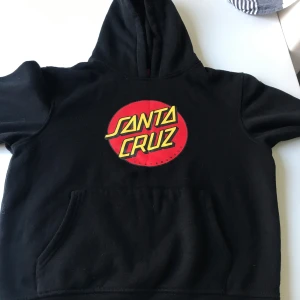  Santa Cruz klädpaket/ hoodies+ beanies  - Cool hoodies  från Santa Cruz med tryck på bröstet och ärmarna. Den har en stor ficka framtill och en bekväm huva. Perfekt för skateparken eller chill dagar. 2 stycken beanies också . Storlek 12-14 åring 