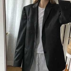 Mörkgrå kavaj från Massimo Dutti - Mörkgrå kavaj från Massimo Dutti köpt på second hand men säljer den då den var för stor för mig. Hittar ingen storlek på men vanligtvis har jag s och tror denna skulle passa m för en oversized passform och L för en vanlig passform.