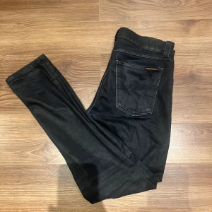 Svarta jeans från Nudie Jeans Co - Snygga svarta jeans från Nudie. Superfint skick, inga fel eller slitningar alls. Hör av dig vid minsta fundering! Nypris: 1600 mitt pris: 599