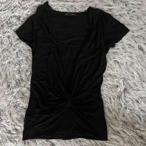 Unik svart t-shirt - Svart unik t-shirt. Knytning längst ner och undertröja under som sitter ihop 