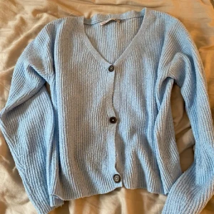 Ljusblå ribbad kofta - Mysig ljusblå kofta med ribbad struktur och knappar framtill. Perfekt för kyliga dagar med sin mjuka och bekväma passform. Den är såå fin men har inte kommit till användning💞