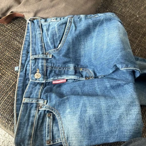 Blå jeans från Dsquared2 - Snygga blå jeans från Dsquared2 med klassisk femficksdesign och logotyp på bakfickan. Tillverkade i en bomullsblandning med lite stretch för extra komfort. Perfekta för en avslappnad stil. Ny pris 2000 använda 2 gånger 