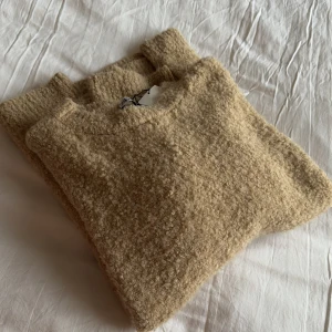 Beige stickad tröja från Zara - Fluffig beige stickad tröja från Zara. Lite oversized strl L. Ny med tags!.