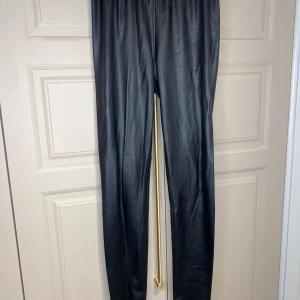 Svarta leggings från Bubbleroom - Snygga svarta leggings från Bubbleroom i syntetmaterial. Perfekta för en stilren look med en tight passform. De har en elastisk midja för extra komfort.