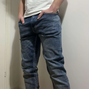 Tiger of Sweden evolve jeans - Snygga blå jeansbyxor med en klassisk straight passform. Perfekta för en avslappnad stil. De har en midwaist design och är tillverkade i slitstarkt denim.