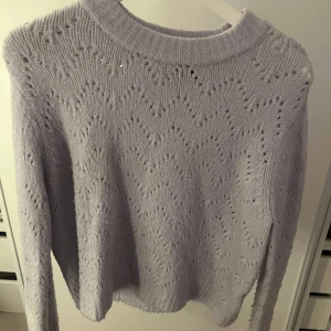 Ljuslila stickad tröja från Pieces - Mysig ljuslila stickad tröja från Pieces med ett fint hålmönster. Storleken är M