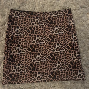 Leopardmönstrad kortkjol - Säljer en supercool leopardmönstrad kjol som är perfekt för en utekväll eller fest. Kjolen har en tight passform och är gjord i ett mjukt och bekvämt material. Den är lätt att matcha med en enkel topp eller en matchande leopardmönstrad överdel för en komplett look. 🐆✨