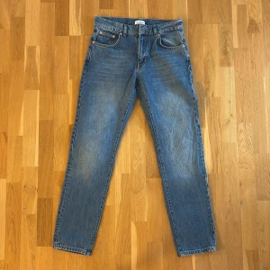 Blå vintage jeans från Woodbird - Säljer ett par snygga blå vintage jeans från Woodbird i storlek 29/32. De har en klassisk straight fit och är i mycket bra skick. Perfekta för både vardag och fest! 🕺