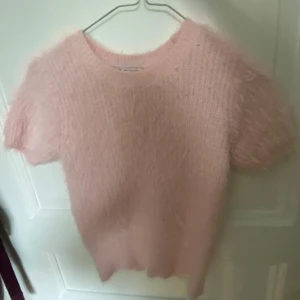 Stickad t shirt  - En jättegosig ljusrosa stickad t-shirt från zara. Bara använd en gång och är i nyskick. Den har en fluffigt päls-aktigt tyg ovanpå och är jättemysig nu på vintern❣️
