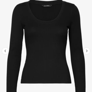 Svart ribbad topp från Monki - Säljer en svart ribbad topp från Monki i storlek Xxs. Den har en snygg u-ringning och långa ärmar, perfekt för både vardag och finare tillfällen eftersom den är enkel men sitter elegant. Toppen är i mycket bra skick och användes knappast. Köpte den för 180 och säljer nu för 80