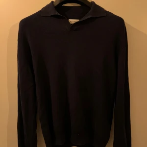 Mörkblå tröja från These Glory Days - Säljer en stilren mörkblå tröja från These Glory Days i storlek medium. Perfekt för både vardag och lite finare tillfällen. Tröjan har en klassisk krage och långa ärmar, vilket gör den idealisk för höst och vinter.