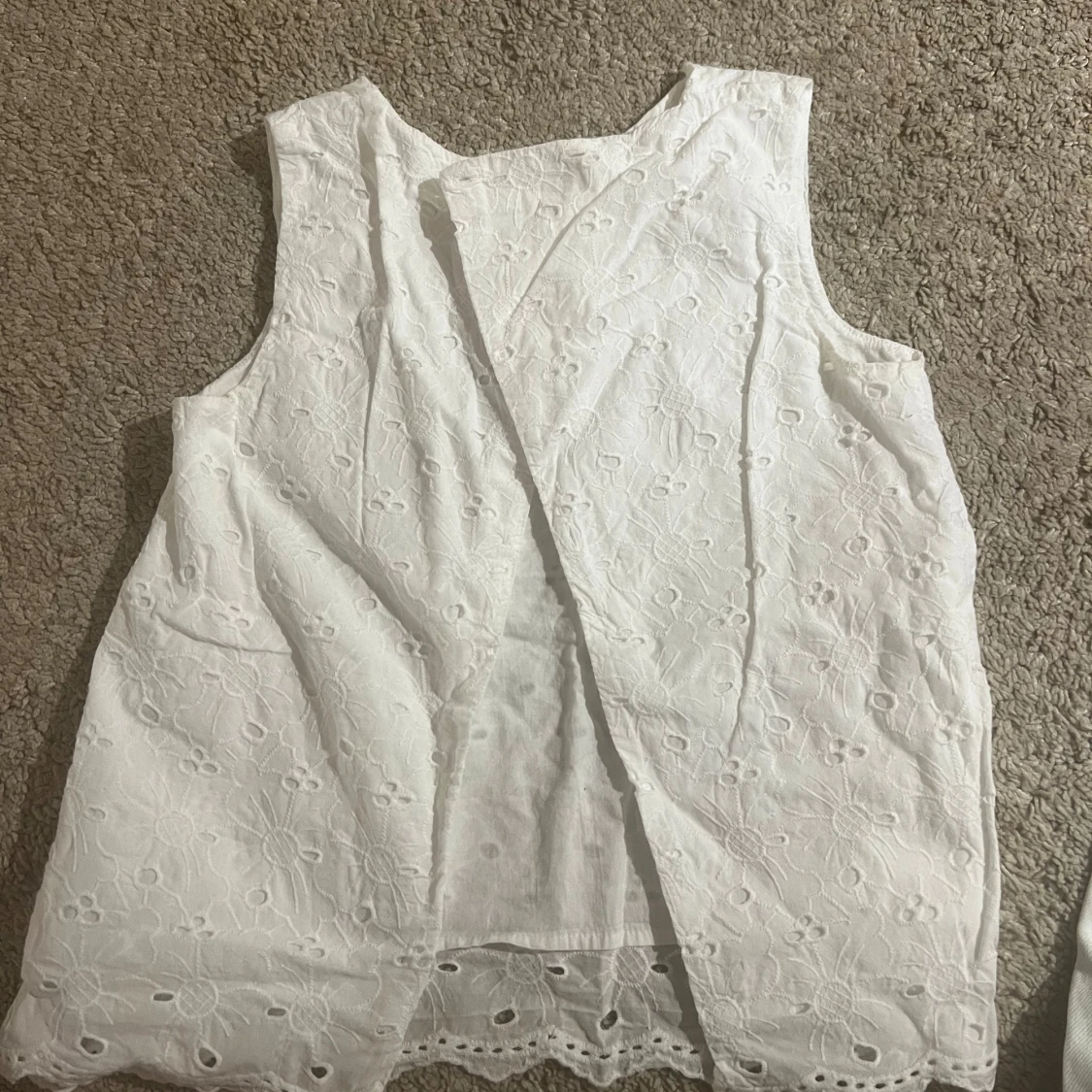 Vit ärmlös topp med broderade detaljer. - 90