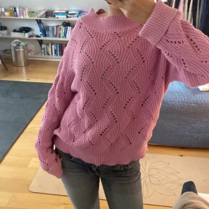 Rosa stickad tröja - Säljer en superfin rosa stickad tröja med ett snyggt vågmönster.Tröjan har långa ärmar och en bred ribbad kant vid halsen💖