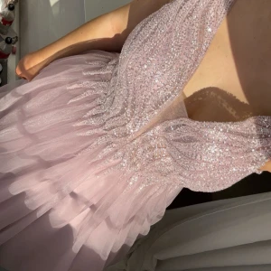 Ljurosa glitter balklänning  - Säljer min otroligt vackra balklänning som är ljusrosa med glitter och paljetter vid överdelen, lång fluffig underdel som består av flera lager så den är inte genomskinlig !! Den är väldigt skön och skaver inte någonstans för mig 💗💗💓💞💕 (kan ha lite lite smuts längst ner men så man inte ser knappt, skriv privat för fler bilder!!) 