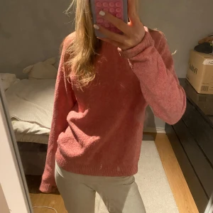 Rosa stickad tröja - Mysig rosa stickad tröja i bra skick. Perfekt för kyliga höst- och vinterdagar. Tröjan har långa ärmar och ribbade kanter som ger en skön passform. Den är både stilren och bekväm, idealisk för vardagsbruk eller en avslappnad dag hemma. Materialet blir sämre varje gång du tvättar den 💕💕