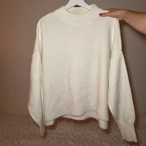 Vit stickad tröja - Mysig vit stickad tröja. Perfekt för kyliga dagar med sin mjuka och bekväma passform. Den har långa ärmar och en ribbad kant vid halsen. Passar både till vardags och mysiga hemmakvällar.