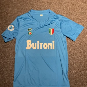 Napoli fotbollströja  - Säljer min Napoli fotbollströja då den har aldrig används. Den är från säsongen 1987/88 med maradona i ryggen där dom kom tvåa i serie A och kom kvartsfinal i coppa italia året efter så vann dom Europa League mot alla odds