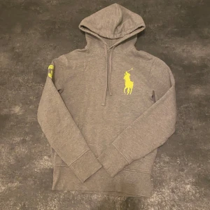 Ralph lauren hoodie - Säljer en snygg grå hoodie från Ralph Lauren. Tröjan är i storlek 165 som motsvarar ungefär XS. Tröjan passar någon som är emellan ungefär 160-170. Passformen är slim.Priset går att diskuteras!