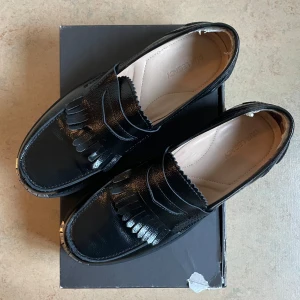 Loafers från Our Legacy - Säljer ett par svarta loafers i skinn från Our Legacy. Endast testade inomhus. Dock har det suttit ”hälkuddar” vid hälen som nu är borttagna därav ser det lite fult ut men inget som stör! 