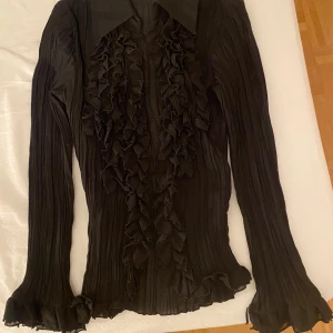 Svart blustopp - Svart blus/ topp i storlek S. Relativt genomskinligt material men den är veckas så man ser inte igenom. Köpt secondhand men använt fåtal gånger. Superfin passform❤️