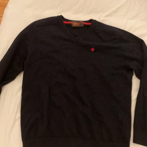 Svart merinoulltröja från Morris - Säljer en stilren svart tröja från Morris i 100% merinoull. Den har en v-ringad design och ett litet rött broderat emblem på bröstet. Perfekt för både höst och vinter, och den är i mycket bra skick. Supermjuk och varm, perfekt för kalla dagar! 🖤(original storlek är XL men har krympt i tvätten och är nu en S ungefär)