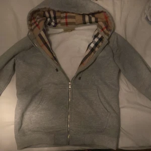 Burberry kofta - En fin grå burberry kofta. Fick den i present men den passar inte så får tyvärr sälja den STORLEK S MEN PASSAR M
