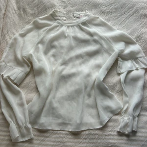 Fin volangblus  - Jättefin meshblus med volanger, genomskinlig, är jättesnygg med en spetsbh eller spetslinne under. Väldigt bra skick, skavank syns på bild 4, fläckarna går säkert att tvätta bort!