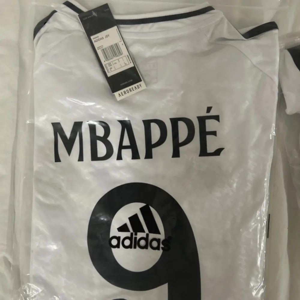 Säljer en vit Real Madrid fotbollströja från Adidas i storlek L. Tröjan har korta ärmar och är i nytt skick med taggar.. T-shirts.