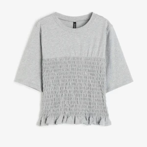 Smockad topp - Supersnygg T-shirt från H&M med en smockad detalj som inte säljs längre. Står xxs i lappen men passar xs eller s bättre! Skriv för fler bilder eller frågor!